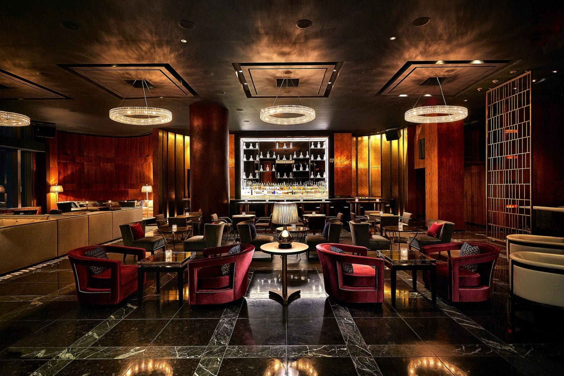 Luxurious romantic restaurant near Central Park featuring dim lighting, plush seating, a sleek bar, and elegant chandeliers for an intimate dining atmosphere.