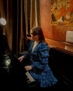 A woman in a blue dress playing piano