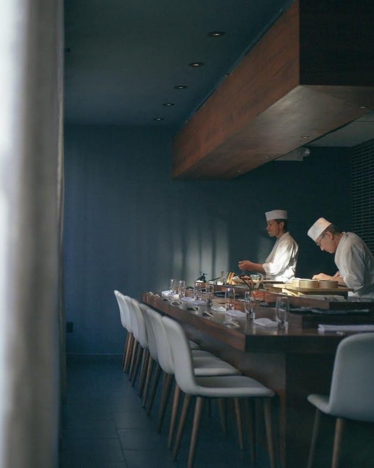 Sushi chefs on a counter. Image by Kosaka.
