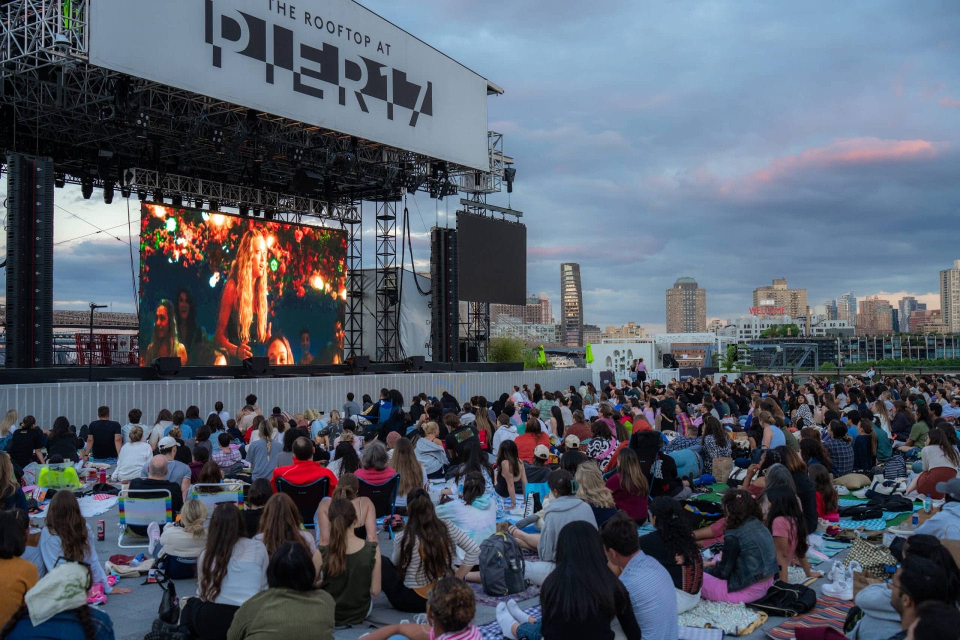 People gathered and watching an outdoor movie at the Seaport Cinema