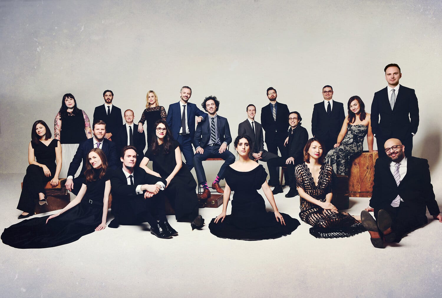 Orchestra members posing for a picture in black tie attire.
