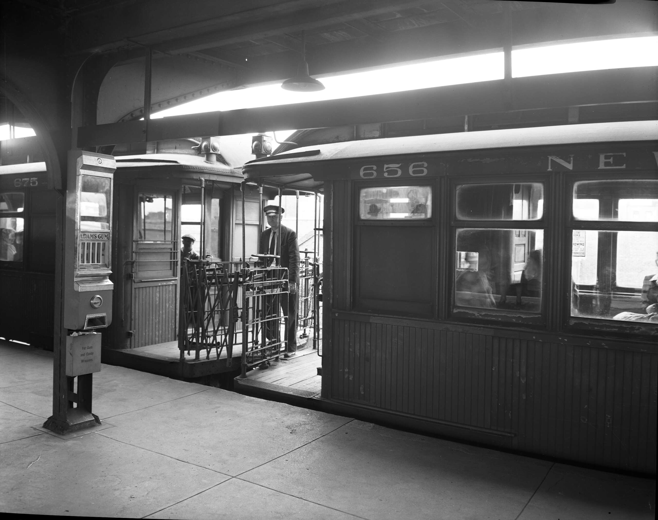 Black and white picture of vintage train car with a train conductor