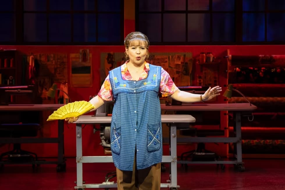 Performer from Real Women Have Curves play on stage.