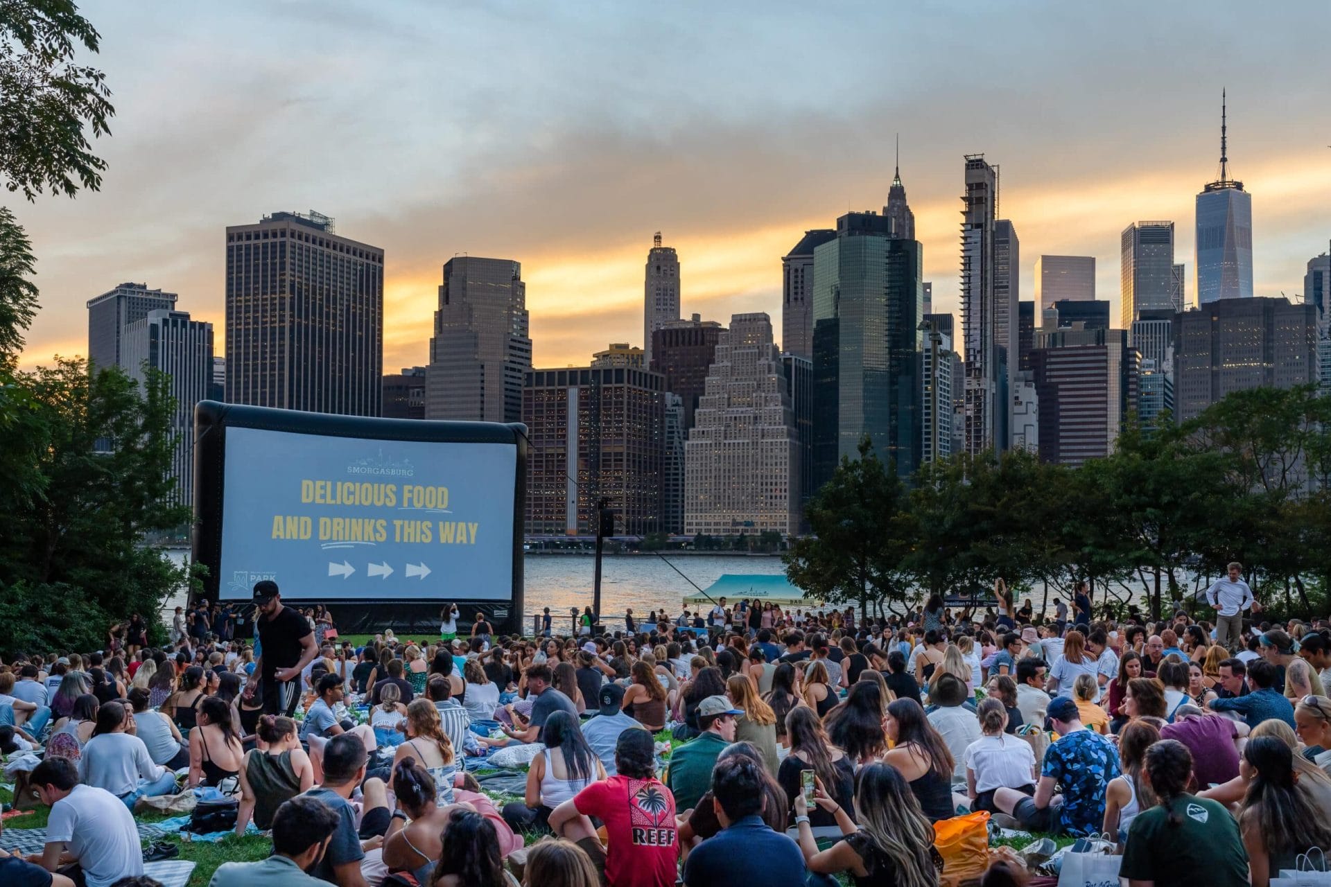 People gathered and watching an outdoor movie at Brooklyn Bridge Park.