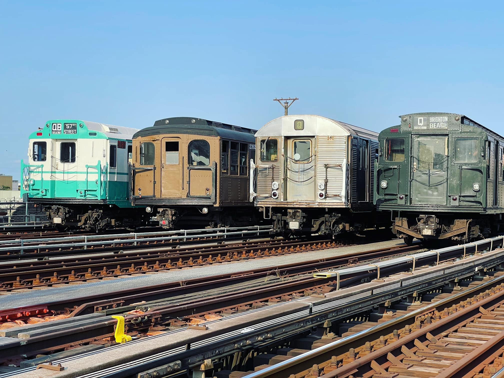 Four trains lined up beside each other on tracks
