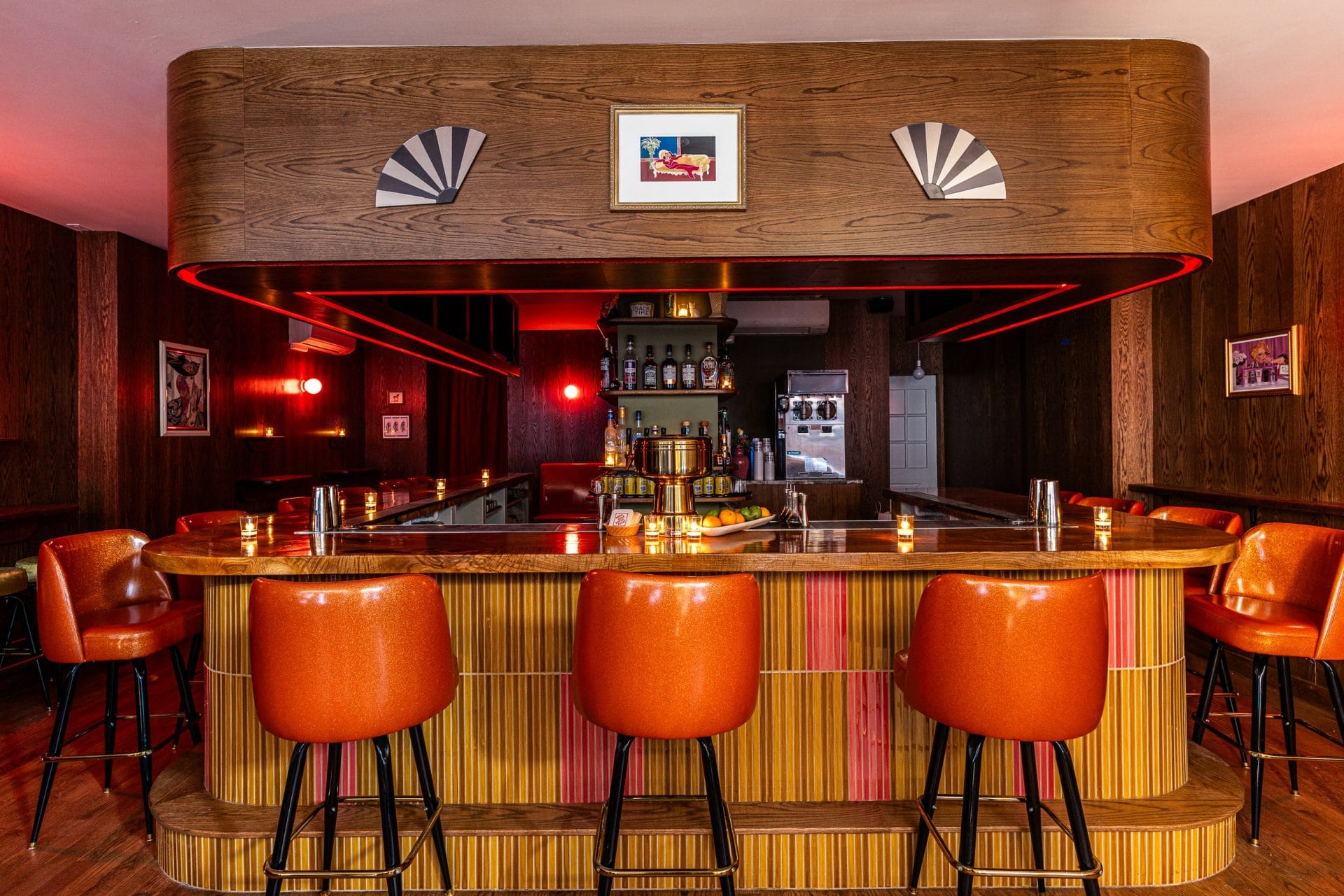 Shot of wooden style bar, surrounded by orange high chairs.