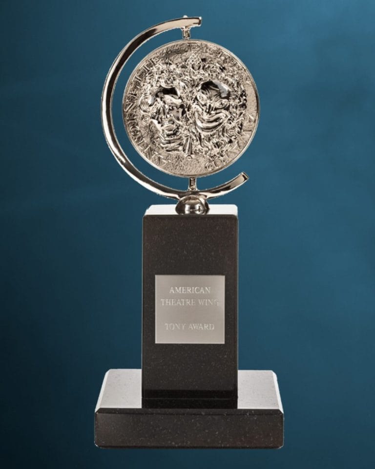 Tony Award Trophy against a blue backdrop.