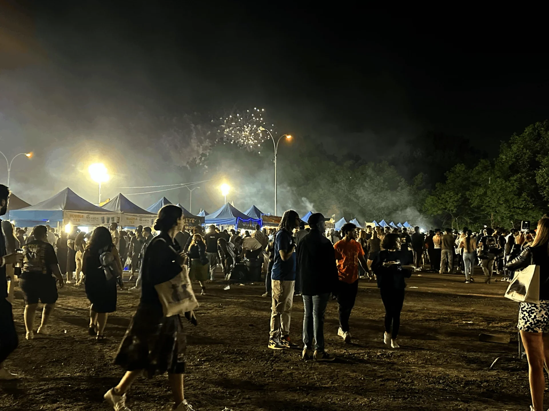 People gathering at Queens Night Market at nighttime. 