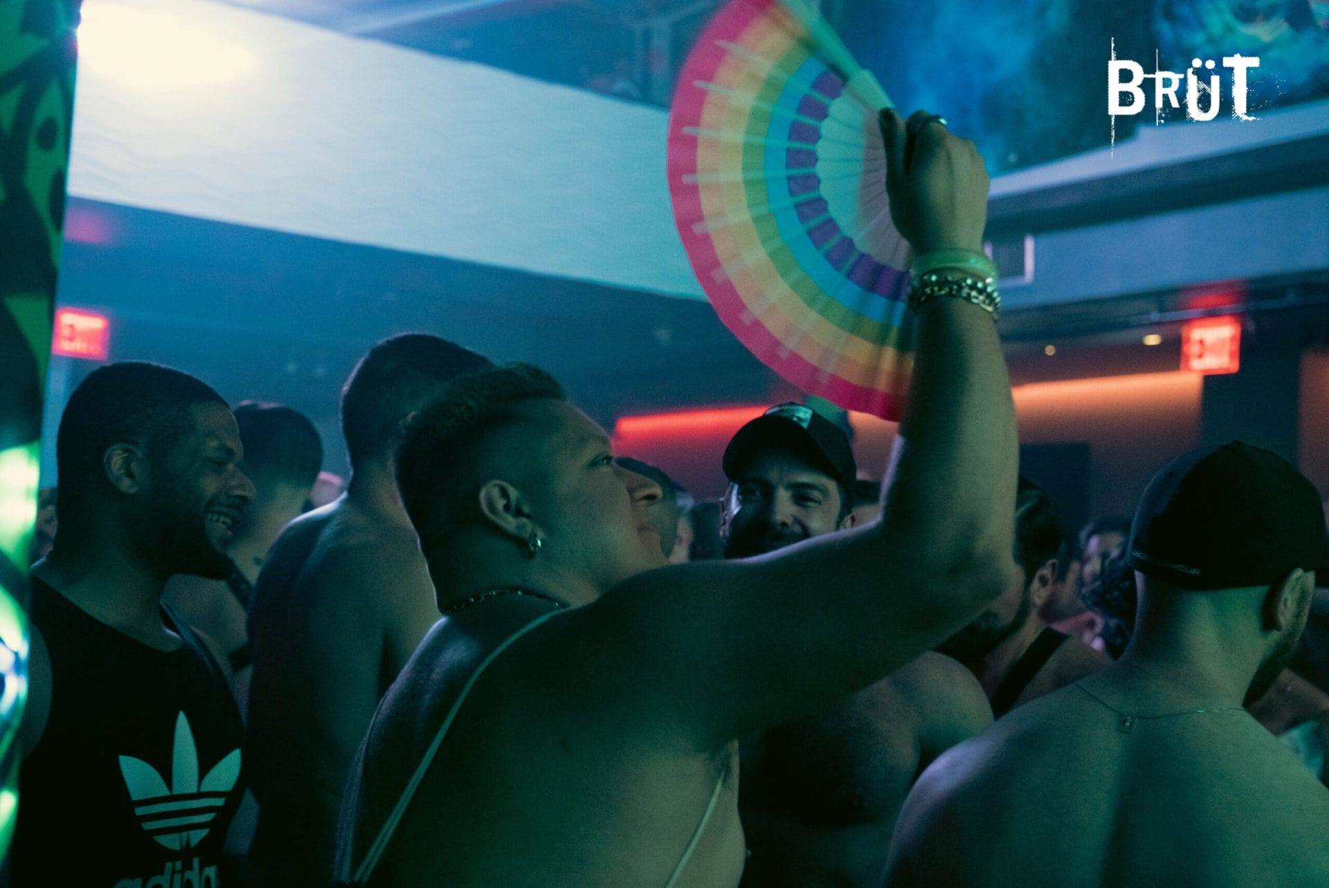 Event attendee holding up a pride themed folding hand fan