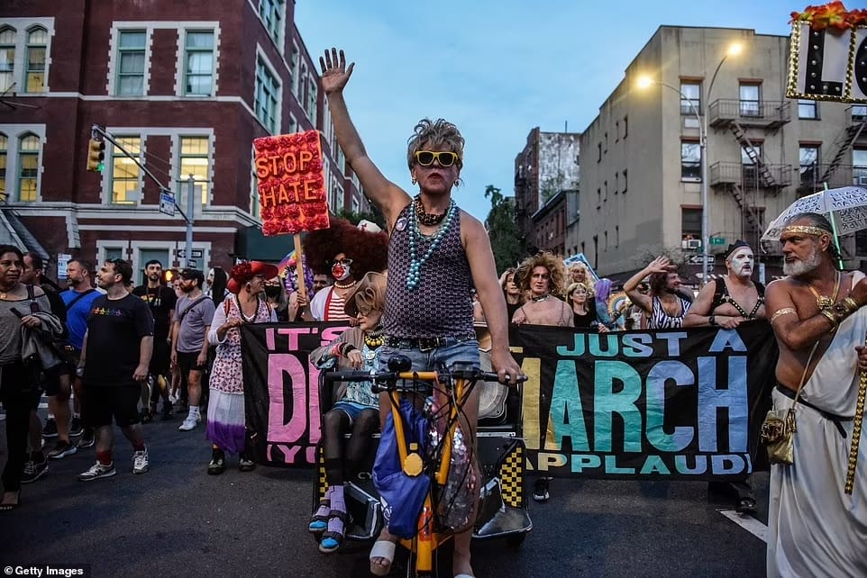 Wide shot of Drag March of people on the street with signs.