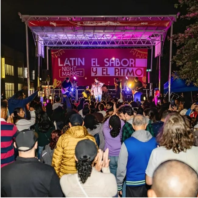 People gathered at a stage at the Latin Night Market