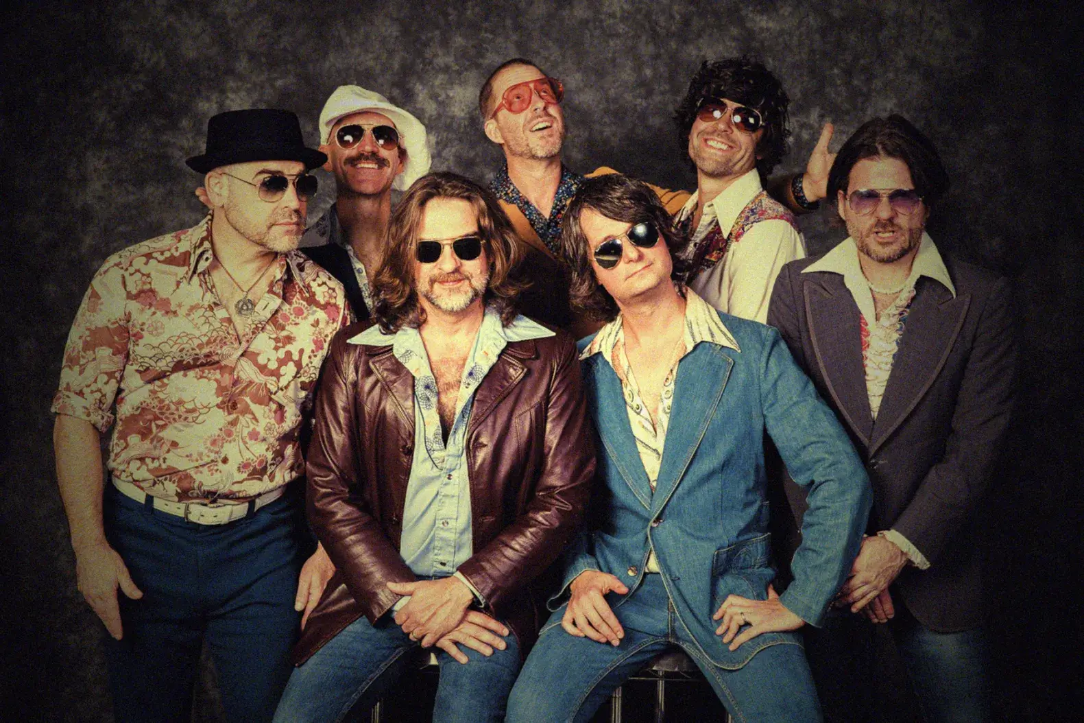 Band Yacht Rock Revue posing in front of a brown backdrop
