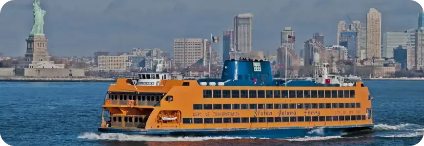 Staten Island ferry on the water with the Statue of Liberty in the back.