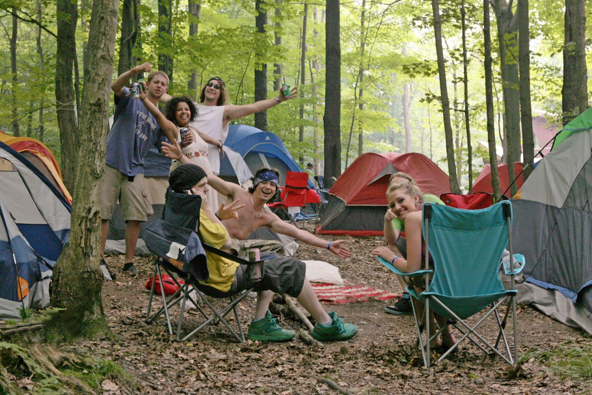 People camping with tents and lawn chairs.